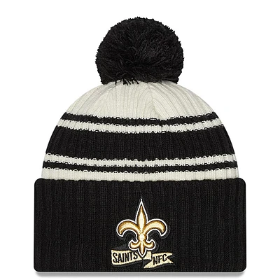 Men's New Era Cream/Black New Orleans Saints 2022 Sideline - Sport Cuffed Pom Knit Hat