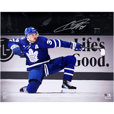 Photographie autographiée de 16" x 20" d'Auston Matthews des Maple Leafs de Toronto, un genou en l'air célébrant la victoire