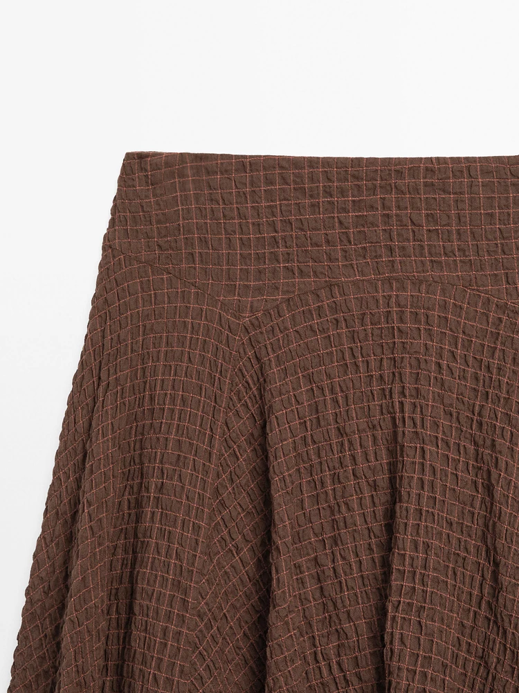Flowing check skirt with asymmetric hem