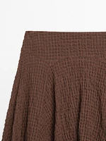 Flowing check skirt with asymmetric hem