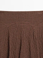 Flowing check skirt with asymmetric hem