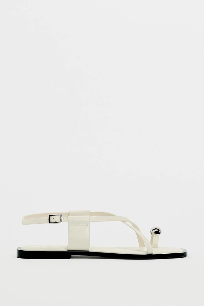 FLAT STRAPPY SANDALS WITH METAL ORNAMENT