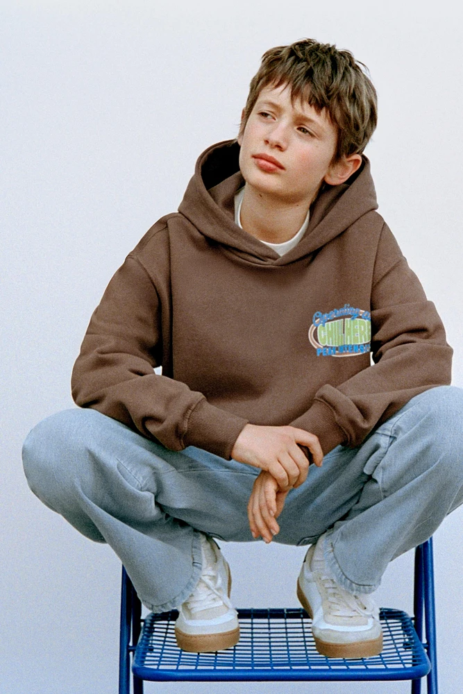 SWEAT À CAPUCHE ET INSCRIPTION