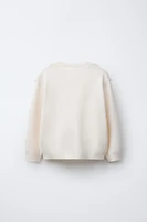 PULL EN MAILLE AVEC DÉTAIL DE DENTELLE BRODÉE