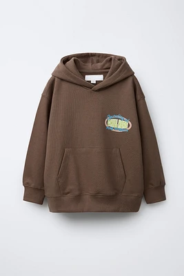 SWEAT À CAPUCHE ET INSCRIPTION