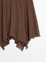 Flowing check skirt with asymmetric hem