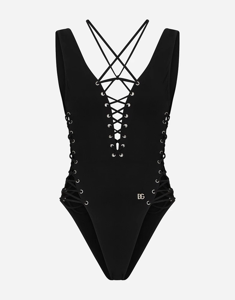 One-piece swimsuit with plunging neckline and lacing and eyelets