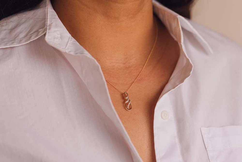 Infinity Pendant with .10 Carat TW of Diamonds in 10kt Yellow Gold with Chain